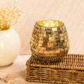 Mosaic golden glass candle holder standing on basket
