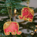 2 red and gold elephants hanging from a christmas tree